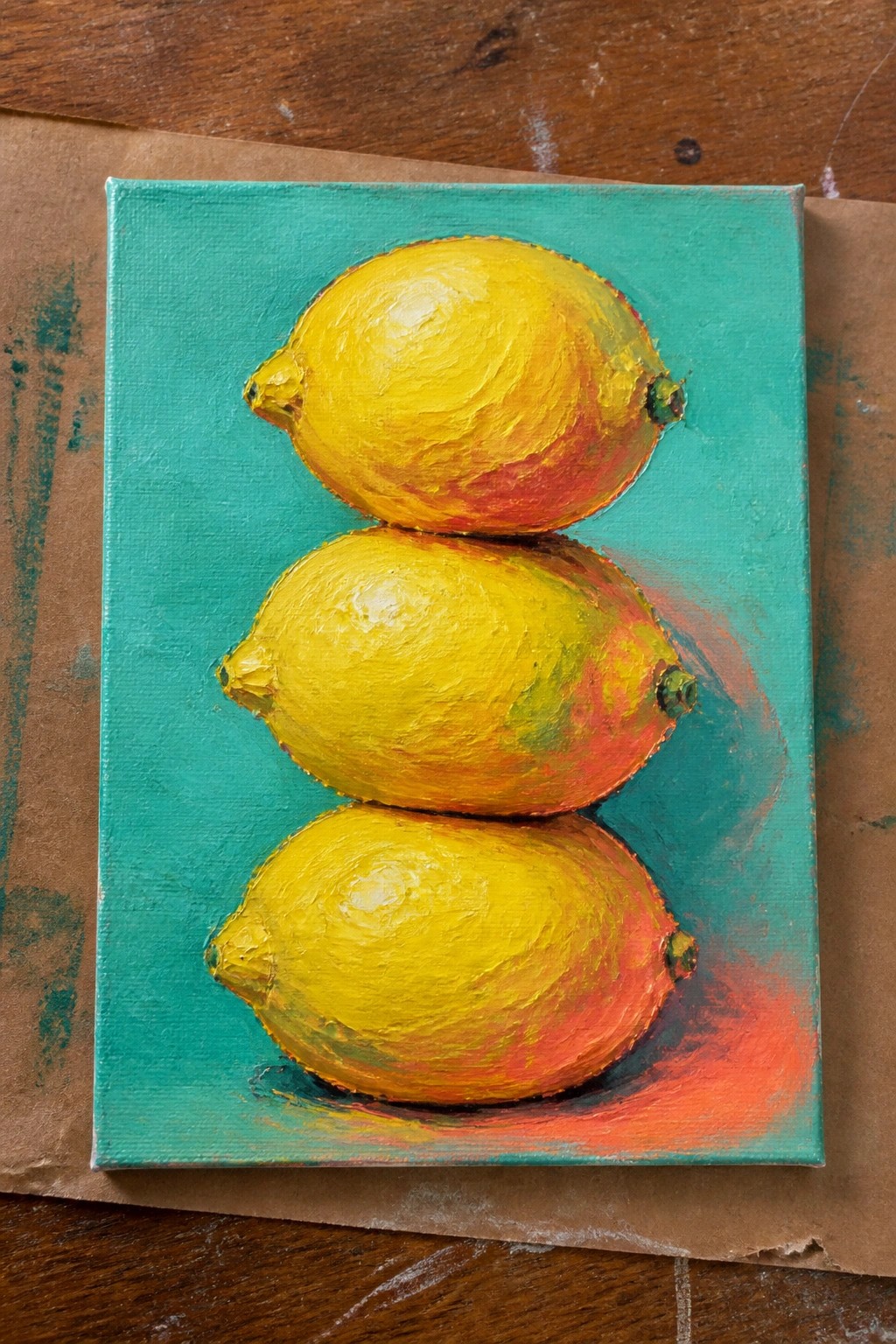 Three yellow lemons with red highlights stacked on a teal canvas with thick brushstrokes.