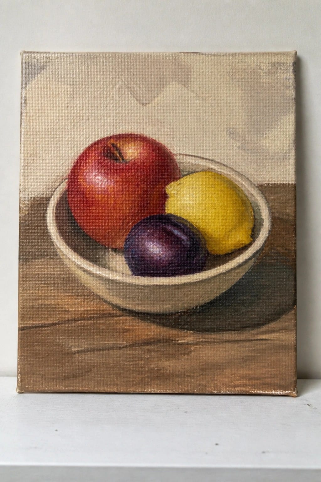 Still life painting of red apple, yellow lemon, purple plum in bowl on wood
