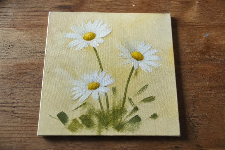 Three white daisies with yellow centers and green leaves on a canvas painting