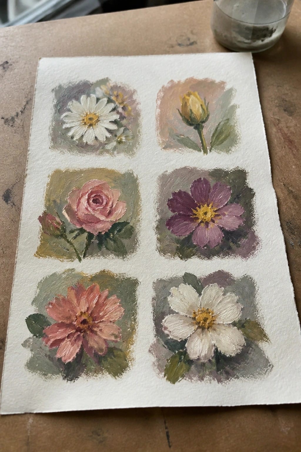 Six watercolor flower studies in grid on white paper atop wooden table.