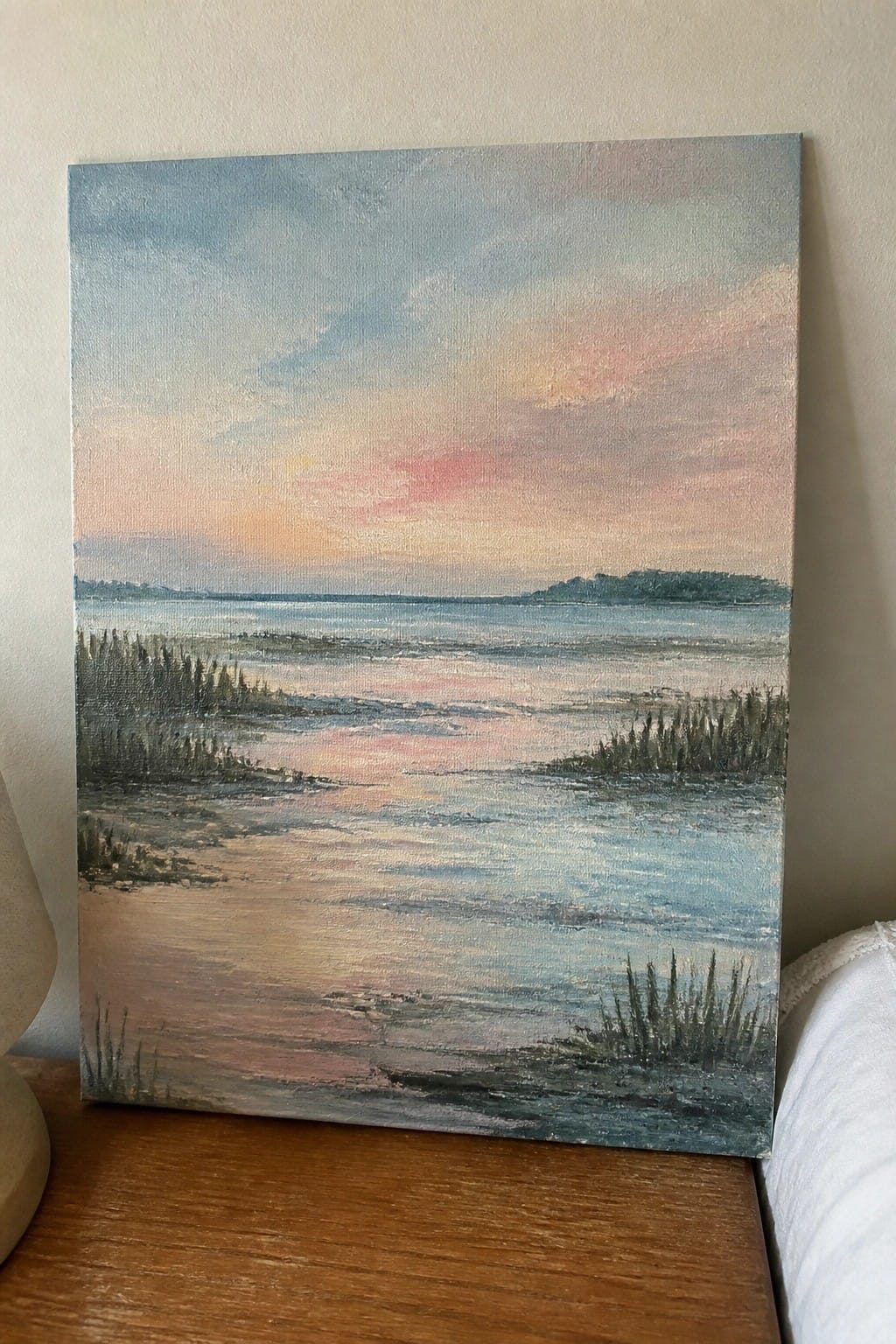 Pastel sunset landscape painting of marshy waters with reeds on canvas.