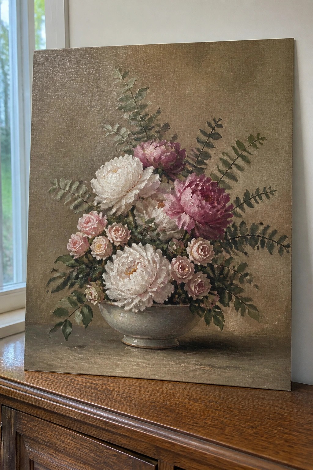 Still life painting of pink and white peonies in a bowl on wood.