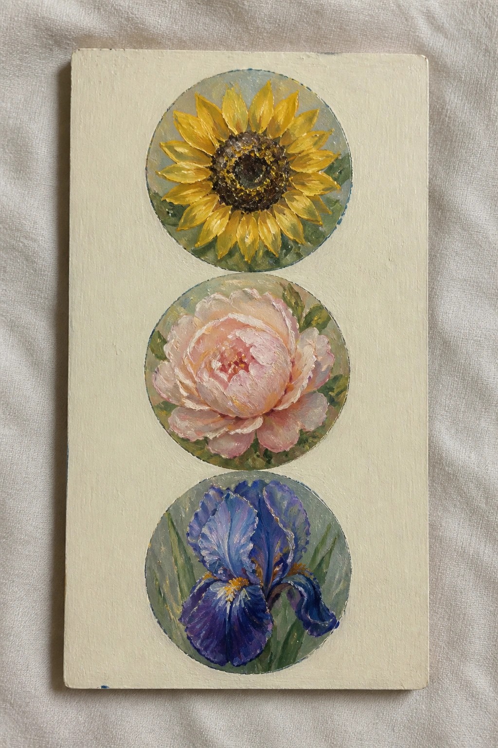 Vertical canvas with three circular paintings of sunflower, pink peony, and blue iris.