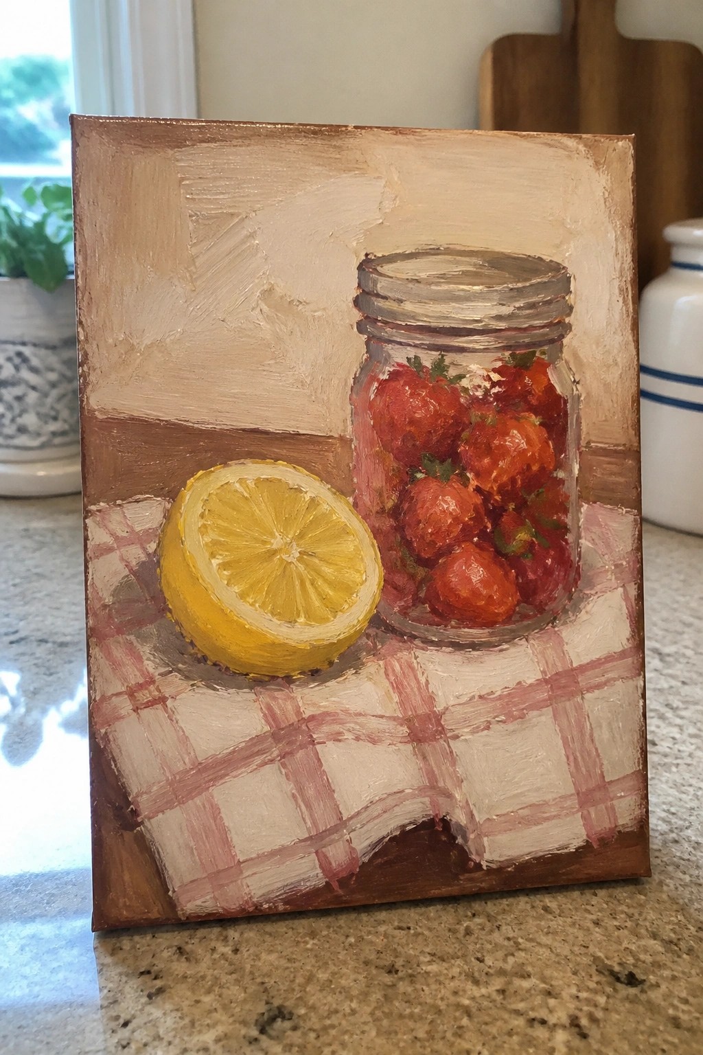 An oil painting of a glass jar filled with strawberries next to a cut lemon on a red and white checkered cloth.