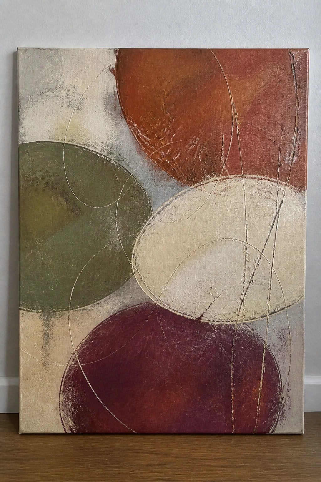 Abstract painting with overlapping circles in rust, olive, maroon, and beige tones.