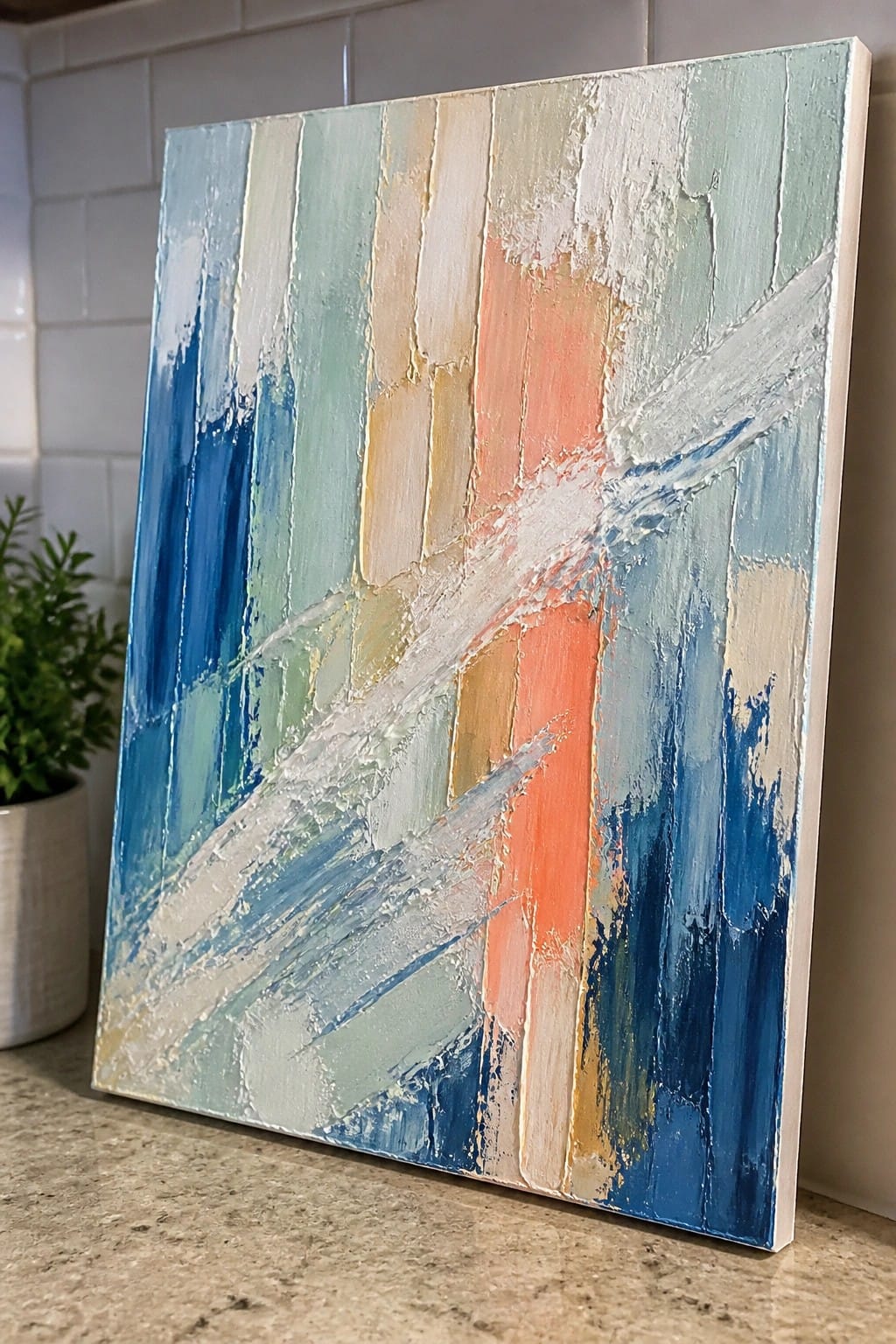 Abstract painting with textured blue green orange white vertical stripes on countertop