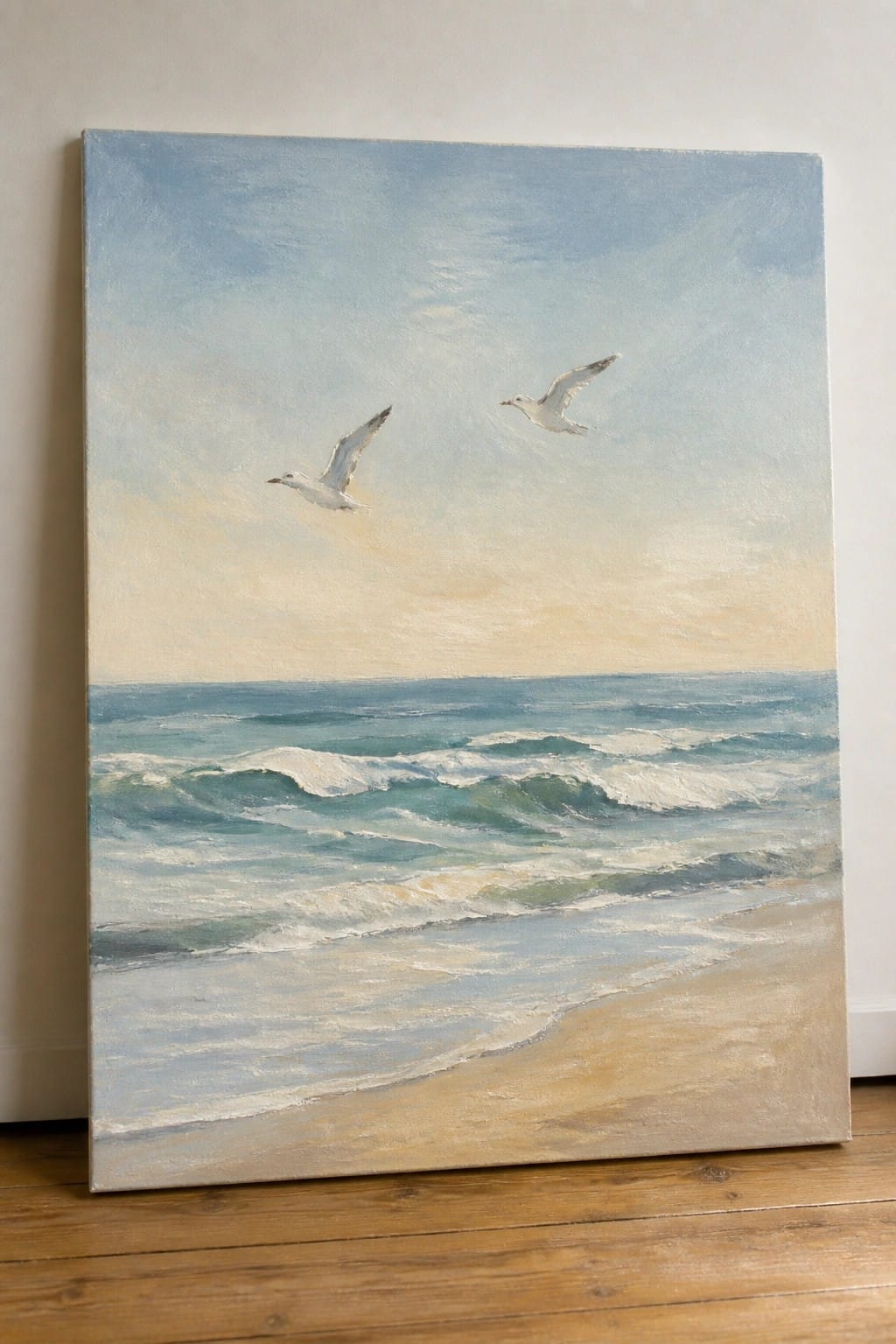 An oil painting of two white seagulls flying over blue-green ocean waves with a sandy beach in the foreground and a pale blue sky.