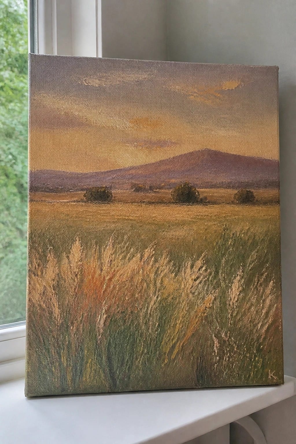 Painting of golden field at sunset with distant hills on windowsill canvas