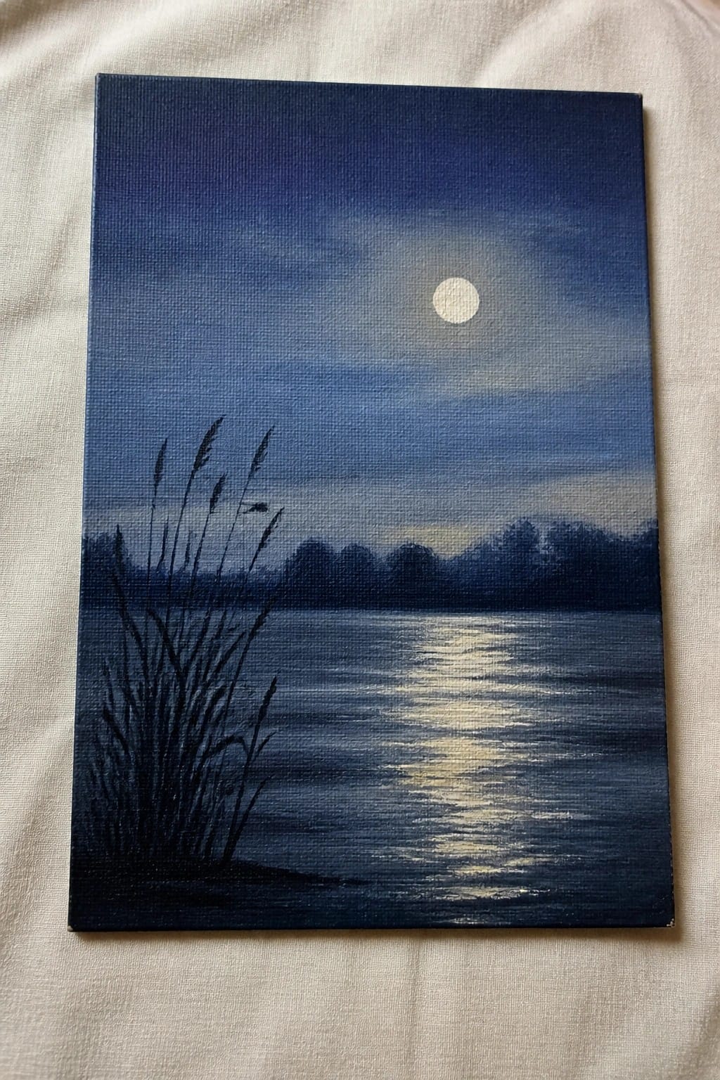 An oil painting of a full moon over dark water with tall reeds in the left foreground and a distant tree line.