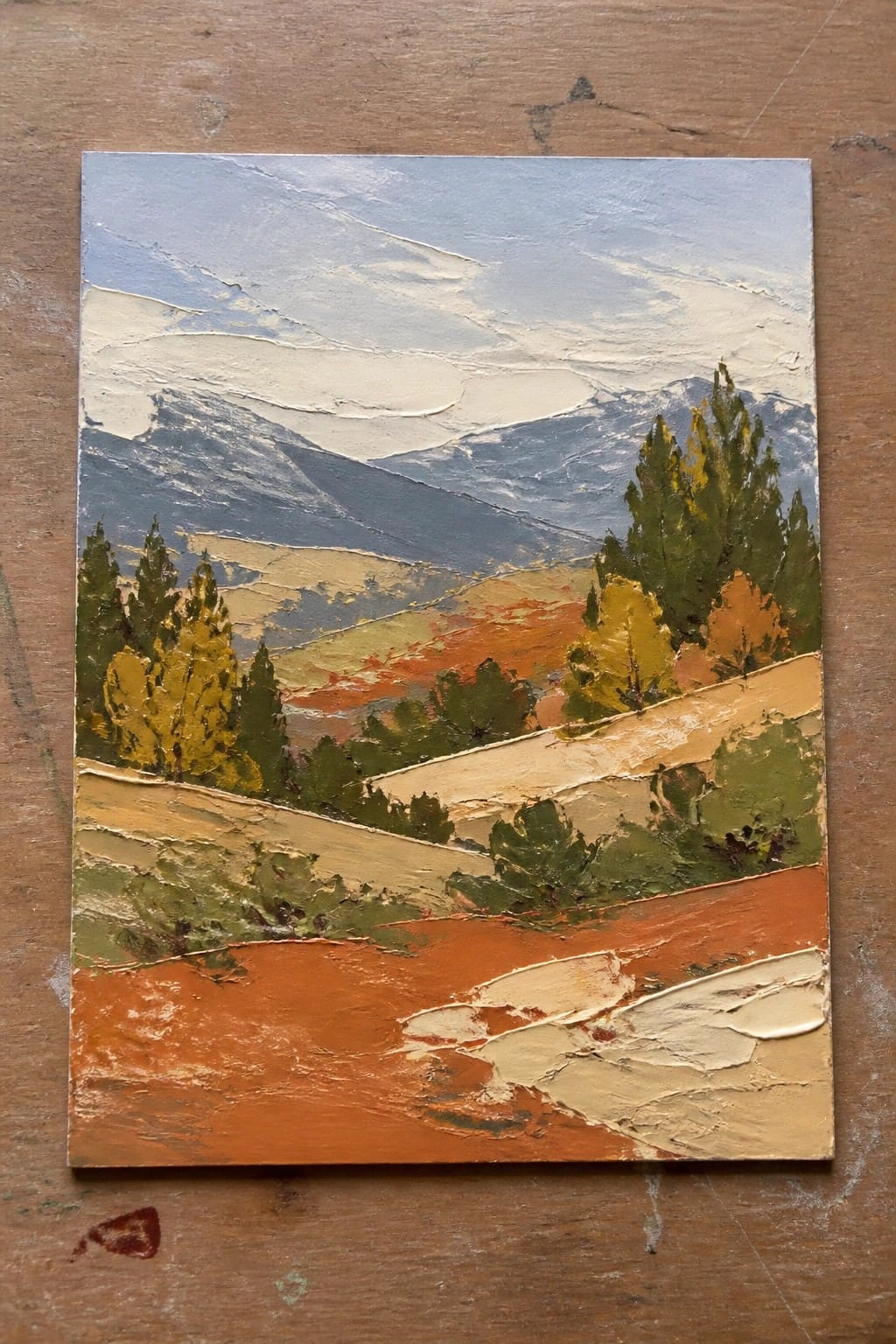 Textured oil painting of autumn mountains, colorful trees, and winding orange hills.