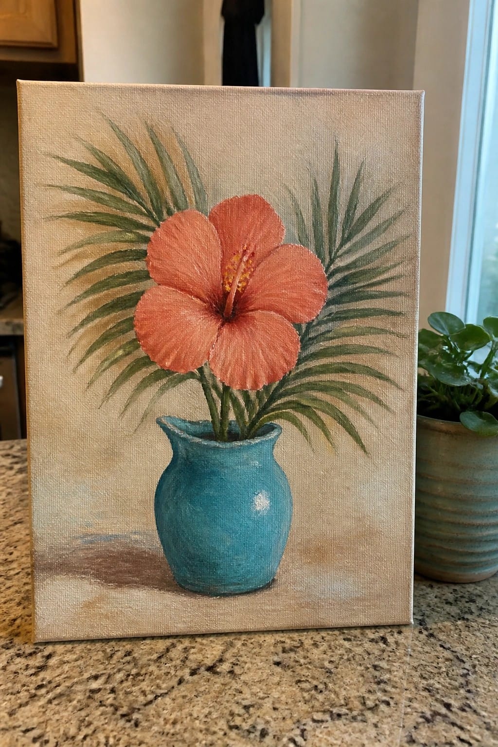 Painting of coral hibiscus in teal vase with green palm leaves on countertop.