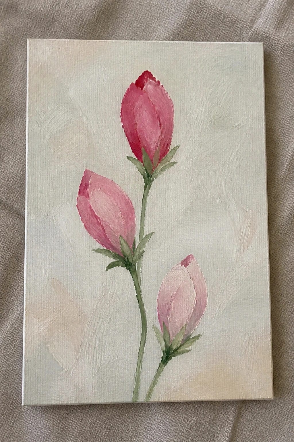 Three pink flower buds on green stems painted softly on a light canvas.