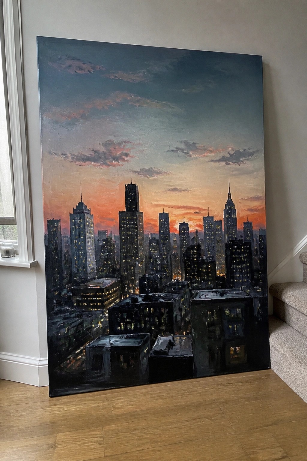 Large oil painting of illuminated skyscrapers beneath a vibrant orange-pink sunset sky.