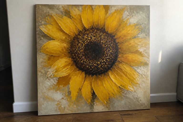 Large sunflower painting with yellow petals leaning against wall on wooden floor