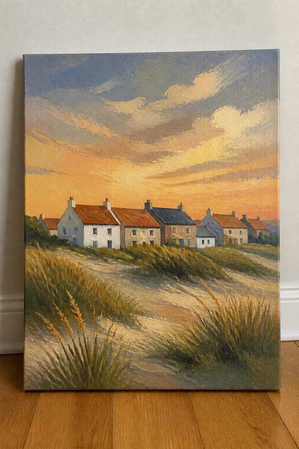 Row of cottages with red roofs along a sandy path under golden sunset.