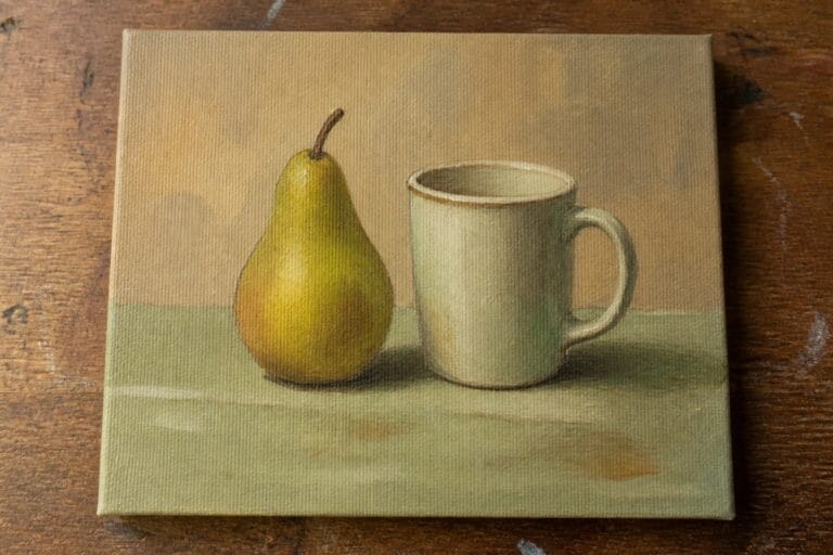 Green pear beside white mug in muted still life painting on wood.