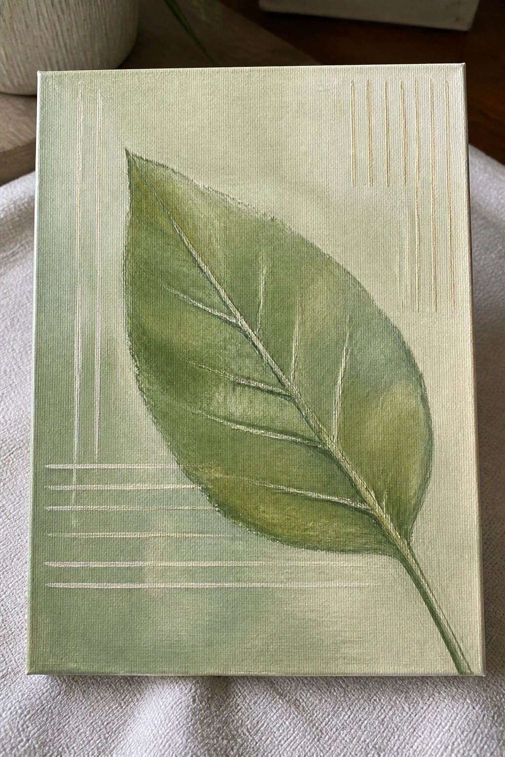 Green leaf painting on pale canvas with white lines and gold accents.