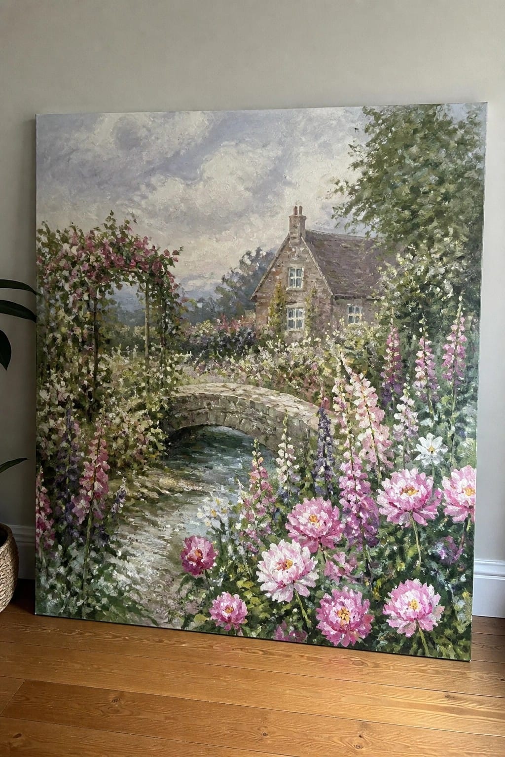 Impressionist oil painting of a cottage garden with pink peonies, hollyhocks, stone bridge, and stream.