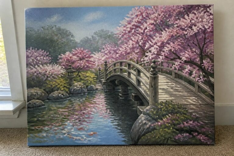 Oil painting of a wooden arched bridge over a pond with koi fish, pink cherry blossom trees on both sides, and stone lanterns near the water.