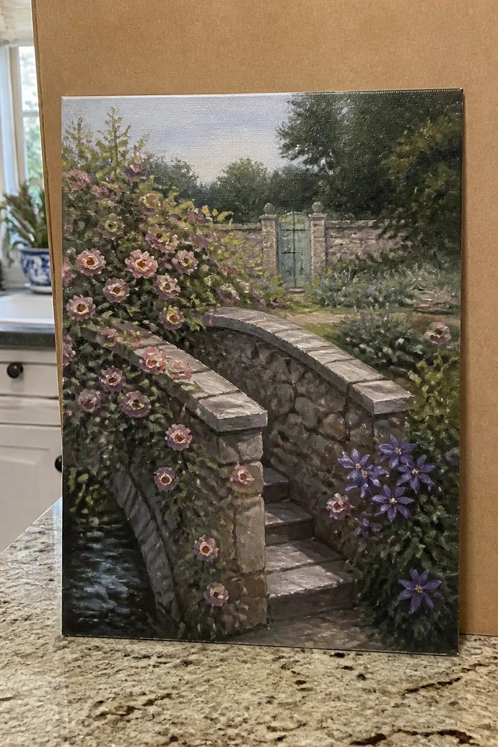 Oil painting of rose-covered stone bridge with steps in lush garden by gate.