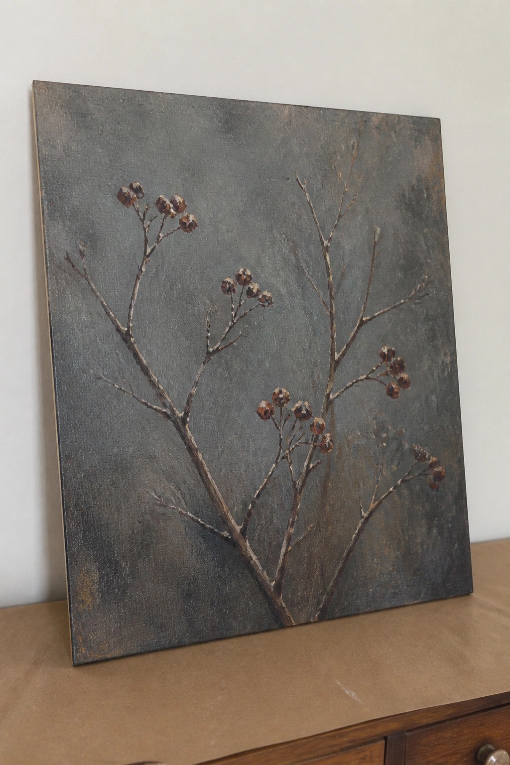 Painting of bare branches with berries on textured dark gray-brown background