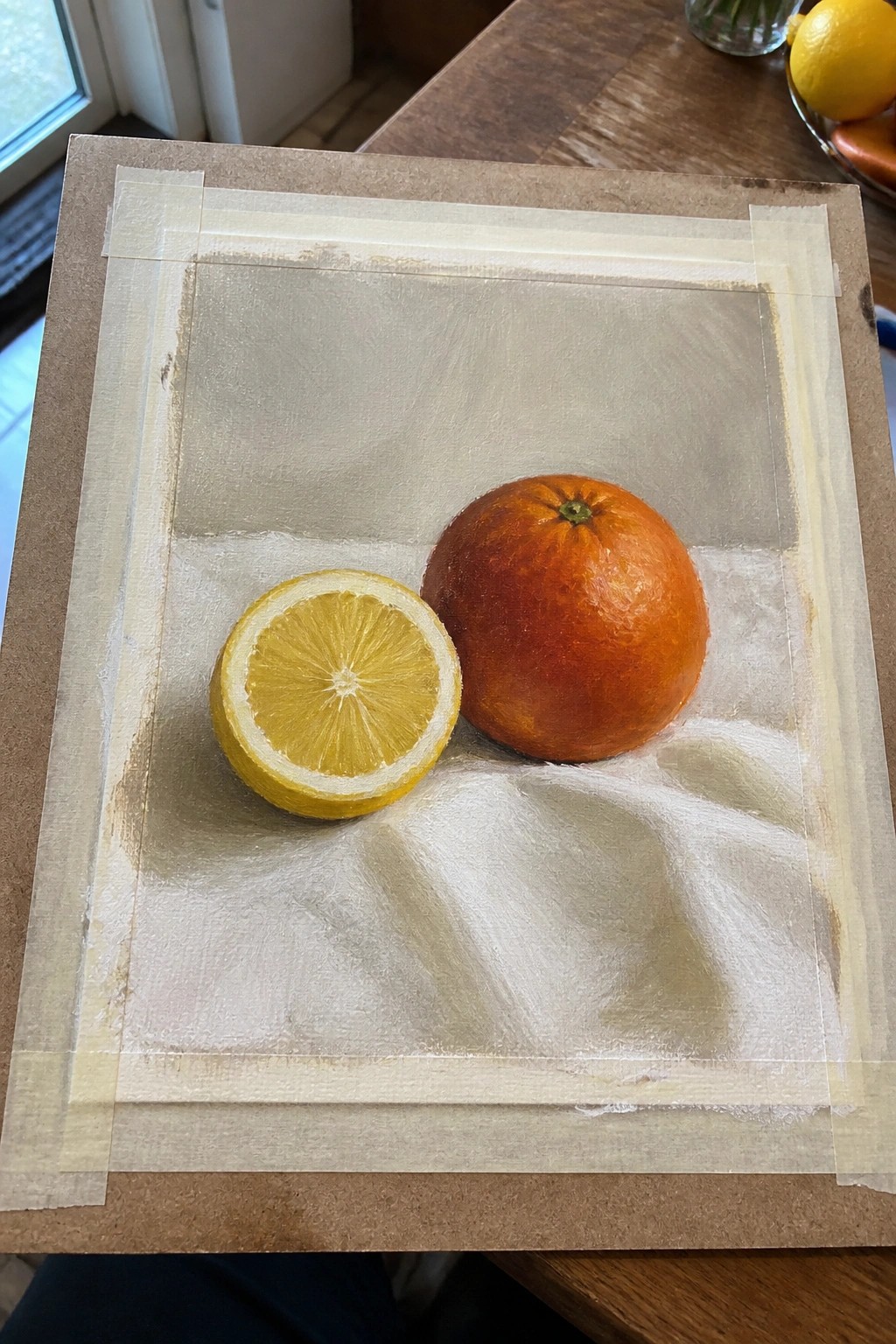 Realistic painting of halved lemon and whole orange on white draped cloth