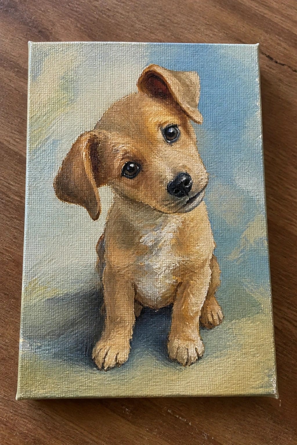 Oil painting of seated brown puppy with floppy ears on canvas