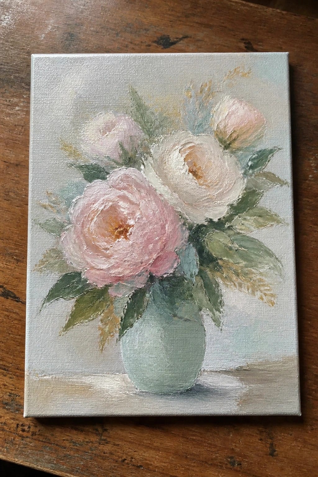 Pastel oil painting of pink peonies in a mint green vase on wood