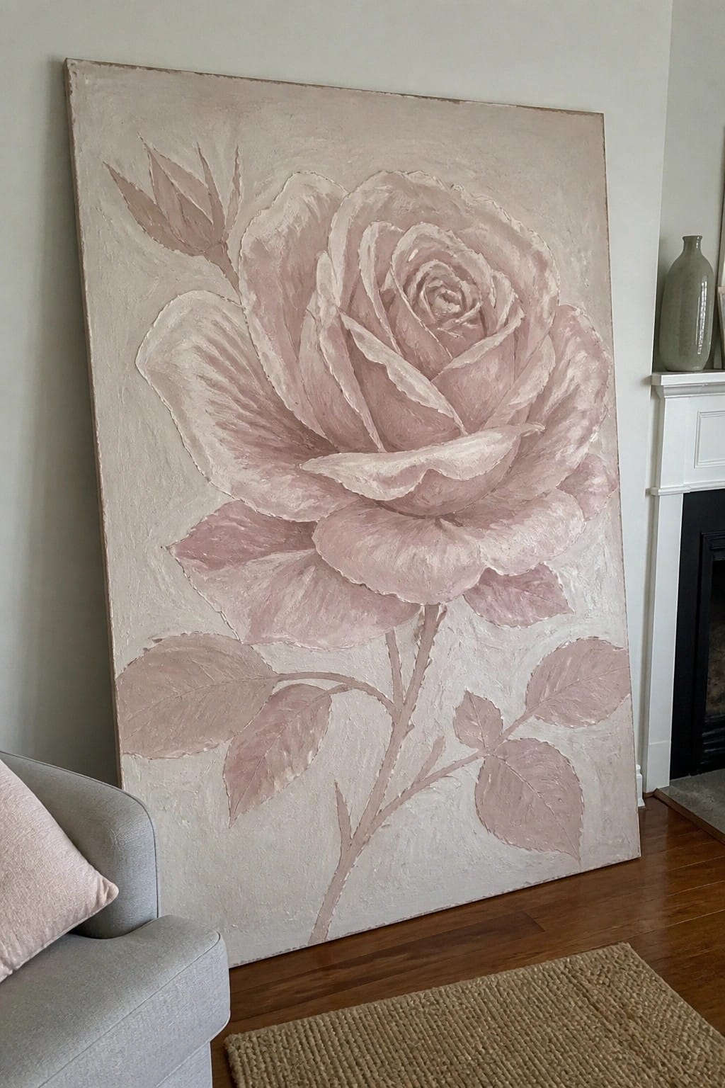 Large textured painting of soft pink rose leaning against wall in living room