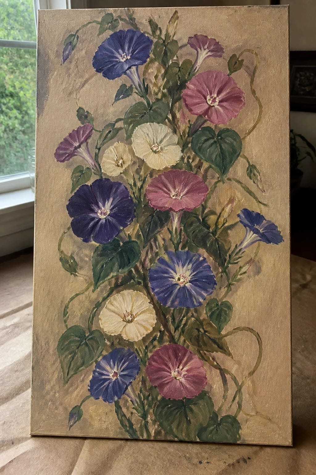 Vibrant painting of blue, purple, pink and white morning glories with green leaves on vines.