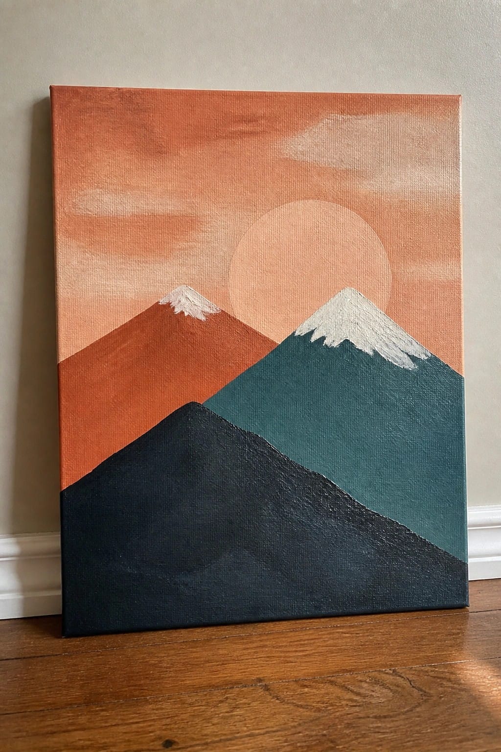 An oil painting of three overlapping mountains in orange, teal, and dark blue with a large pale sun in an orange sky.