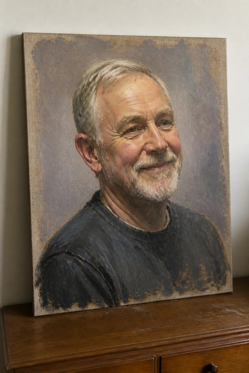 Portrait painting of smiling older man with gray beard in dark sweater on wooden dresser