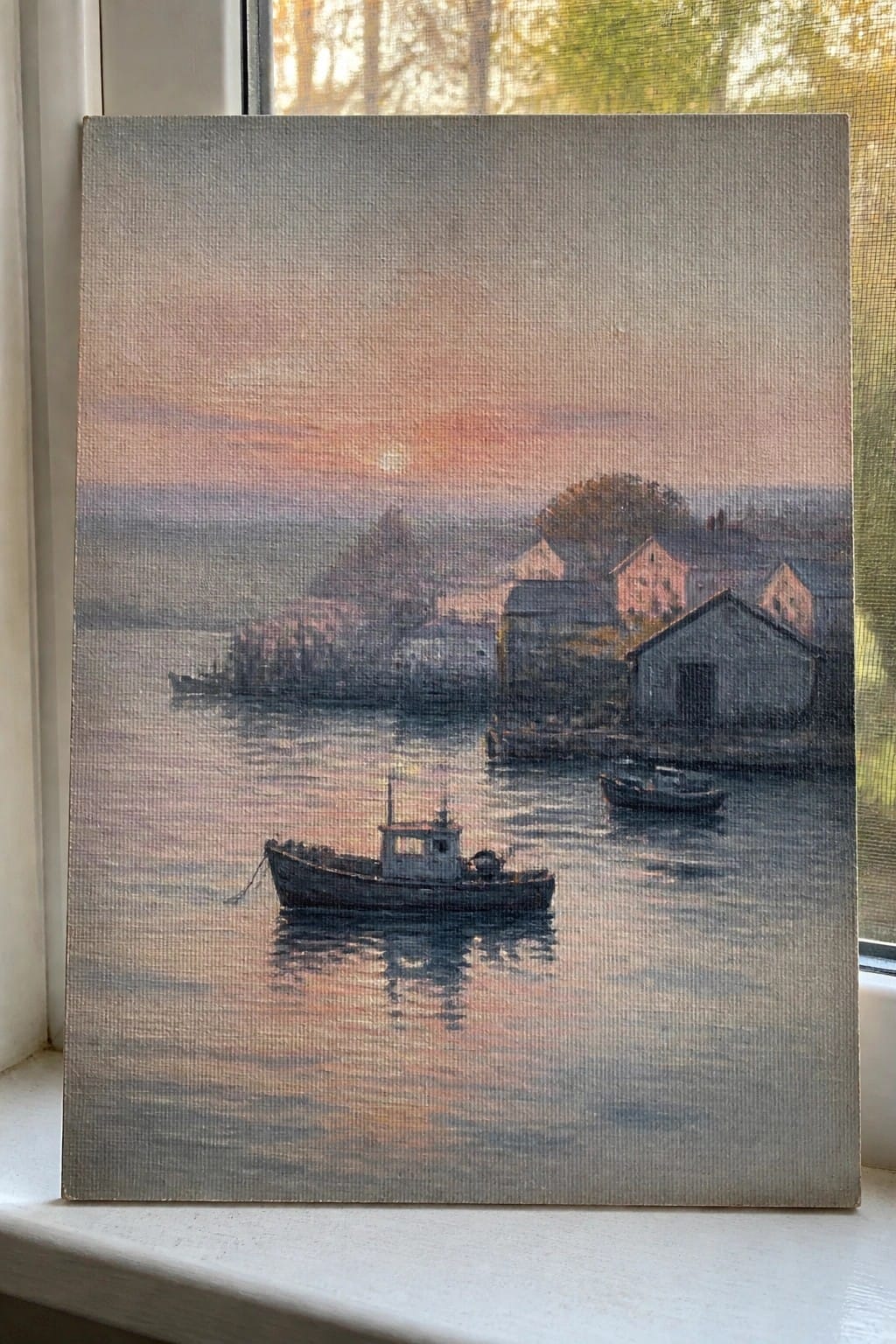 Painting of boats on calm harbor waters at pink-orange sunset with shore buildings.