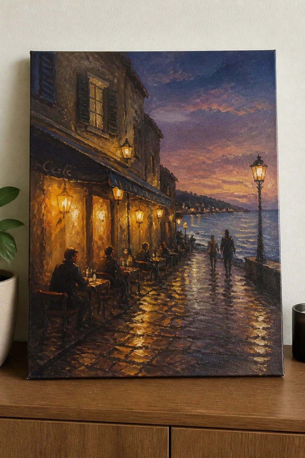 Evening seaside café painting with diners under lanterns on glowing wet cobblestones by the sea.