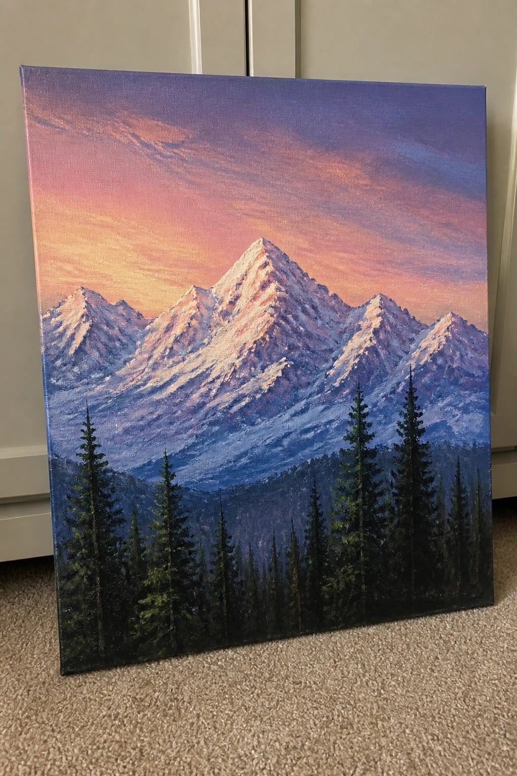 Acrylic painting of snow-capped mountains at sunset with dark pine trees in front