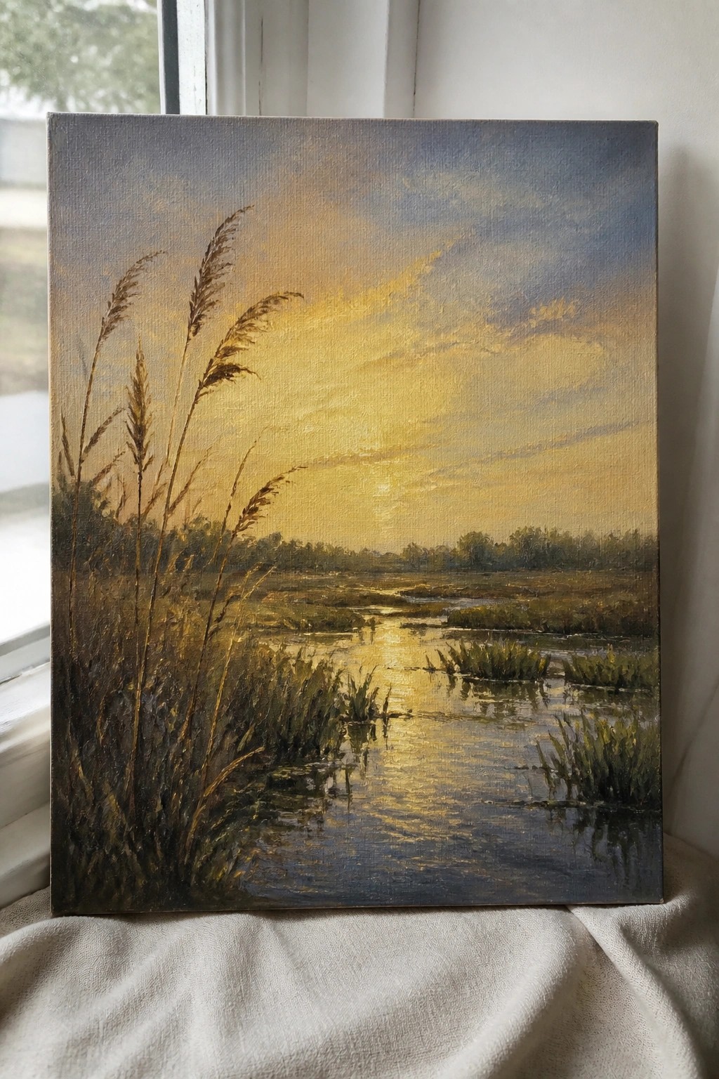 Sunset painting over marsh with tall grasses, golden sky, and reflective water.