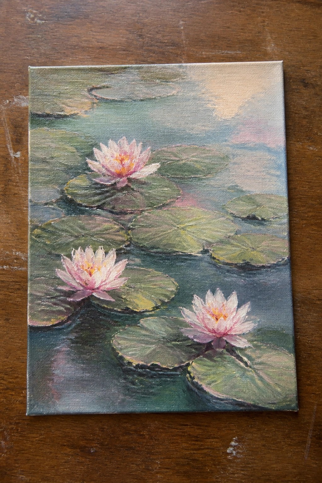 Pastel painting of pink water lilies floating among green lily pads on a pond